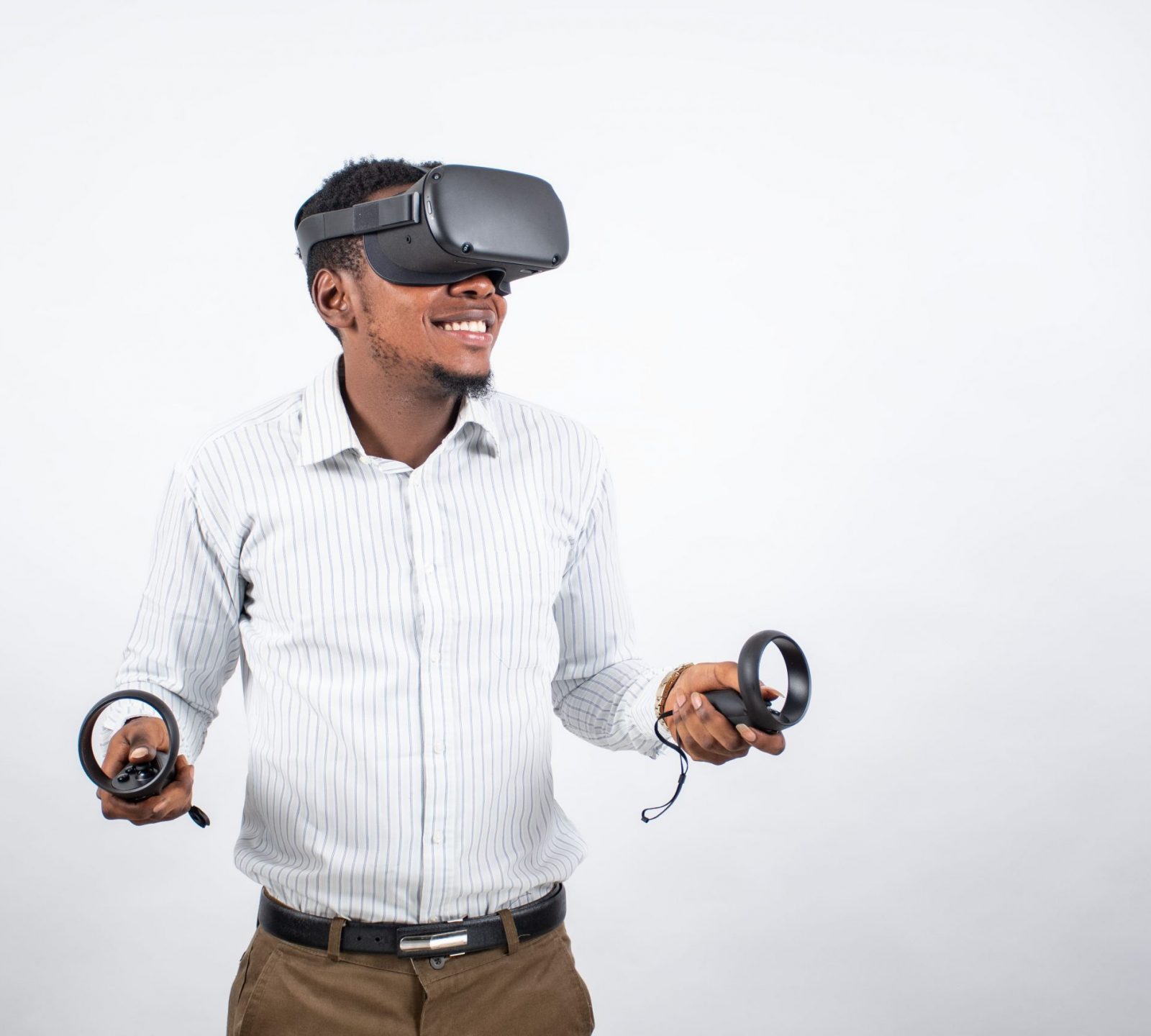 young-black-man-smiling-while-using-vr-headset-controllers-min